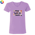 A light purple short-sleeve V-neck t-shirt with a colorful graphic on the chest that reads 'DOGS MAKE ME HAPPY' surrounded by cute Halloween-themed illustrations like a pumpkin, ghost, witch hat, and spider. A small multicolor color wheel icon is in the top-left corner.