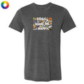 A dark heather gray t-shirt with a colorful graphic on the chest that reads 'DOGS MAKE ME HAPPY' surrounded by Halloween-themed illustrations like pumpkins, ghosts, and a cat. A multicolor color wheel icon is visible in the top-left corner.
