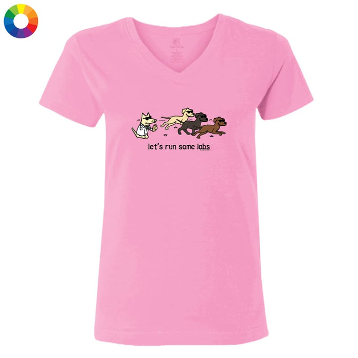 A pink women's V-neck t-shirt featuring a cartoon graphic of a white cat chasing three dogs with the text 'let's run some labs' underneath, displayed on a solid white background.
