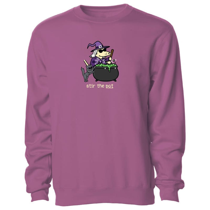 A dusty purple crewneck sweatshirt featuring a cartoon graphic of a witch stirring a cauldron with the text 'stir the pot' printed below it.