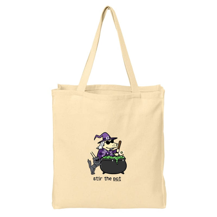 A natural beige canvas tote bag with a cartoon witch stirring a cauldron of green potion, with the text 'stir the pot' printed below the illustration.